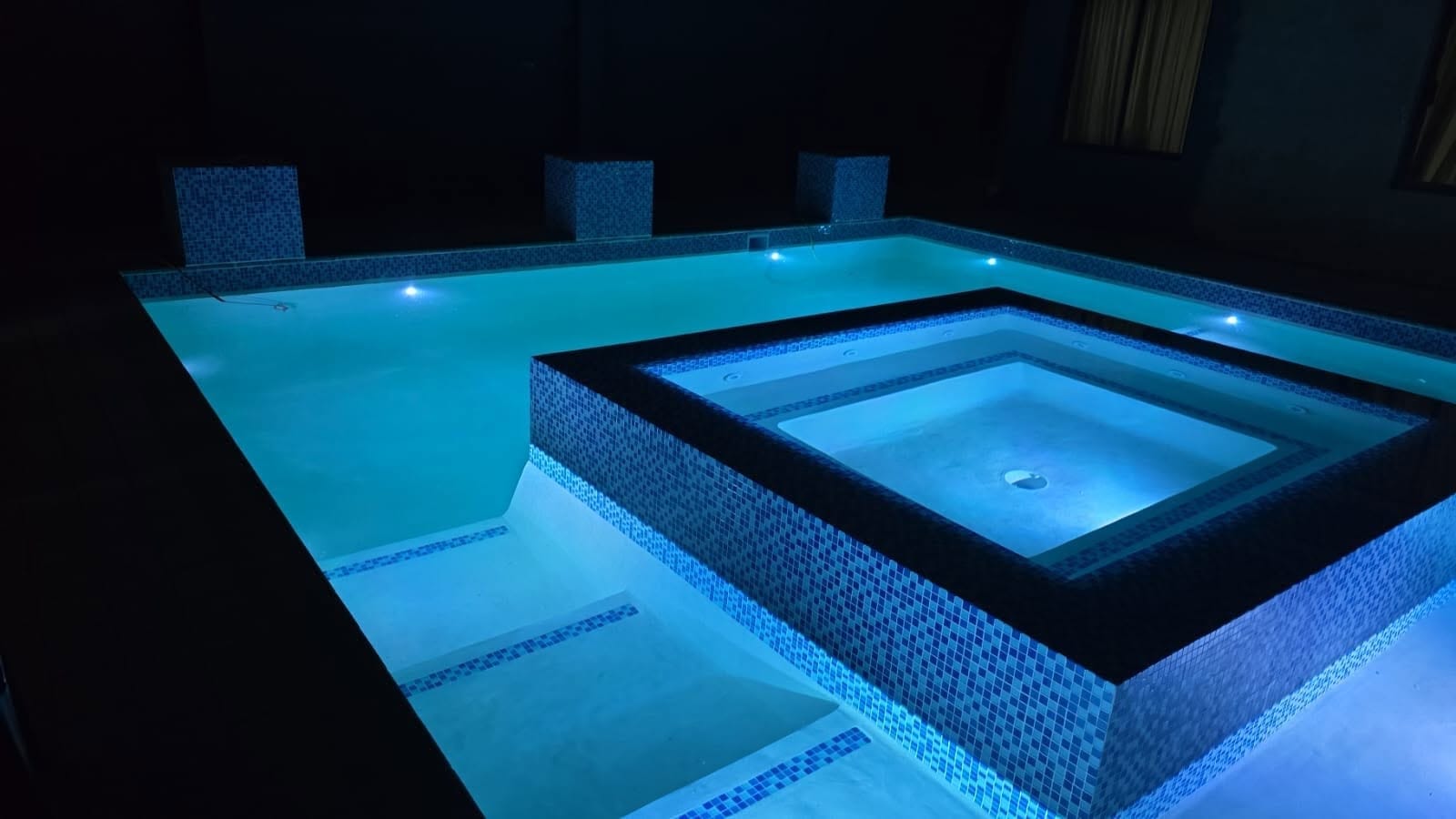 Finished pool with integrated raised spa, glowing blue lit water at night - SGS Pool Specialist Sandringham spa renovation